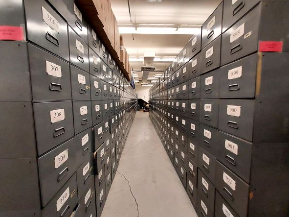 two rows of filing cabinets in a hallway row, long enought to have a vanishing point in the distance