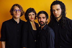 five people posing against a dark yellow background
