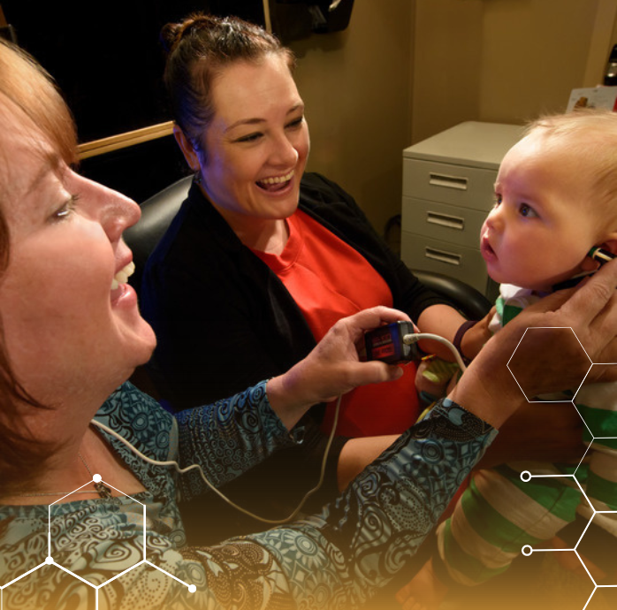 a person with a stethoscope examining baby.