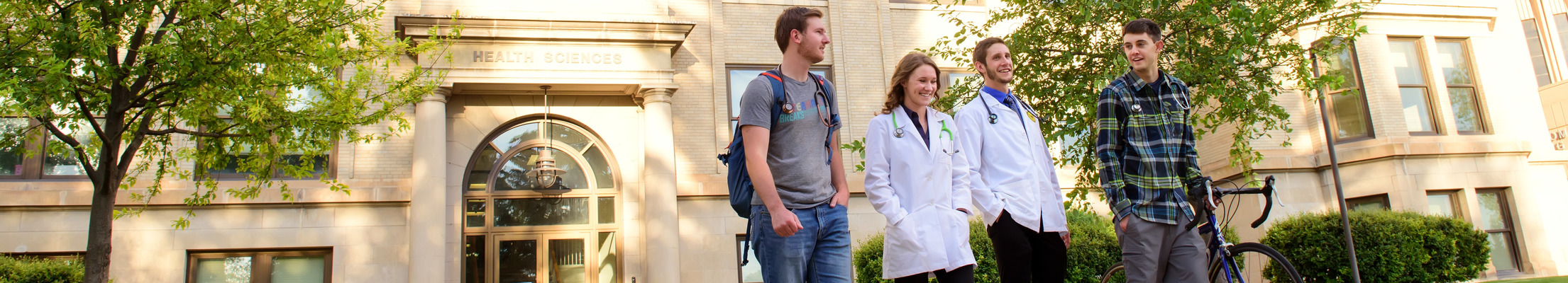Students in a group walking outside the health sciences building