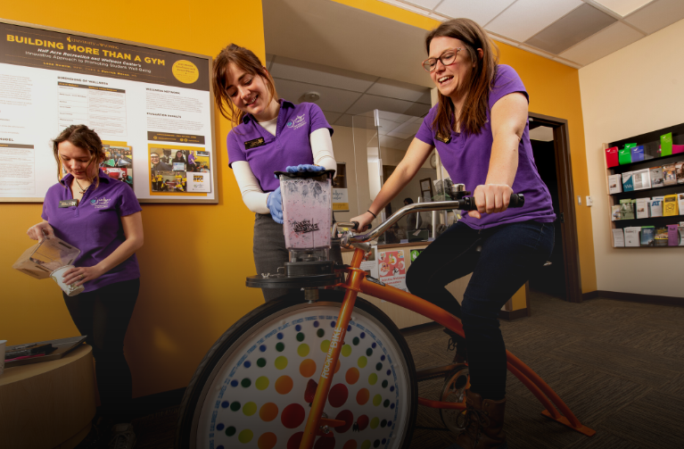 Wellness Center Employees on the smoothie bike