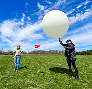 Two people launching a large research balloon