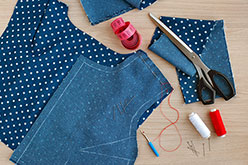 Blue denim vest pieces being pinned together