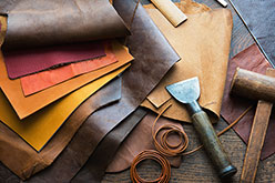 Multi-colored leather pieces on table with tools.