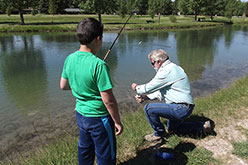 Boy and man fishing at a pond