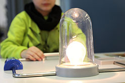 boy doing an electric current experiment with a lightbulb