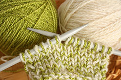 Green and beige yarn on knitting needles