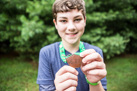 boy showing award medal