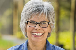 mature smiling female volunteer in glasses