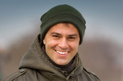 Smiling man in green knit cap and coat