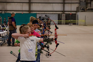 archery line of youth with bows at full draw