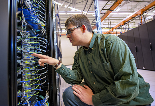 student inspecting server's hardwires