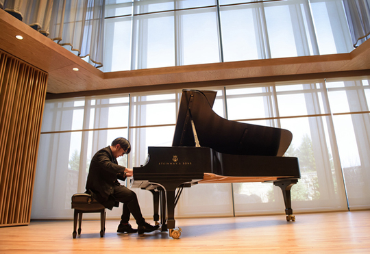 student playing piano in performing center