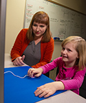 UW Assistant Professor Breanna Krueger works with Rue Steidley, age 7, as a computer software progra