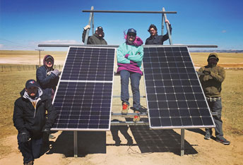 group of people with two solar panels