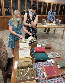 two people looking at books on a table