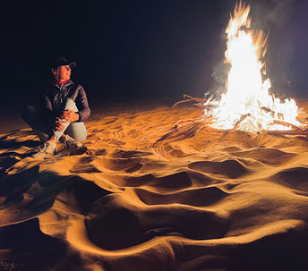 person at a bonfire on a beach