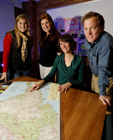 Students and professor viewing a map.