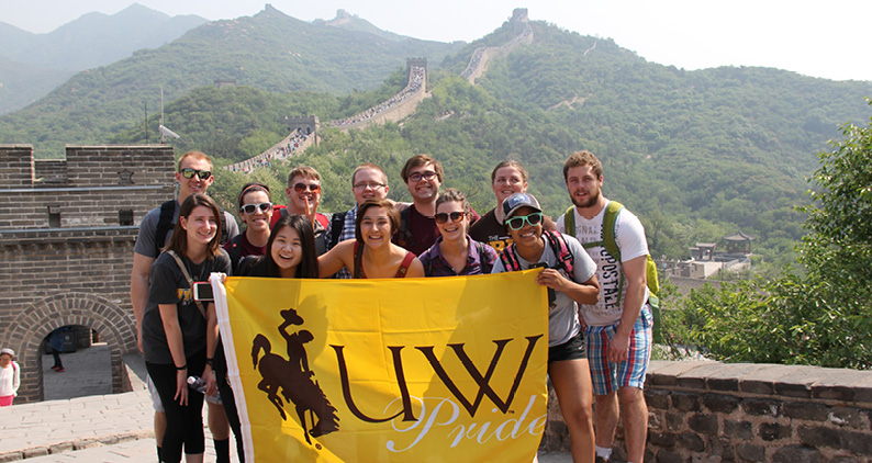 Students at the Great Wall of China holding "UW Pride" banner