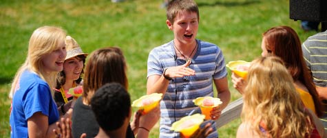 An orientation leader talks with students outside