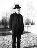 Roberts wearing black clergy clothing and round hat