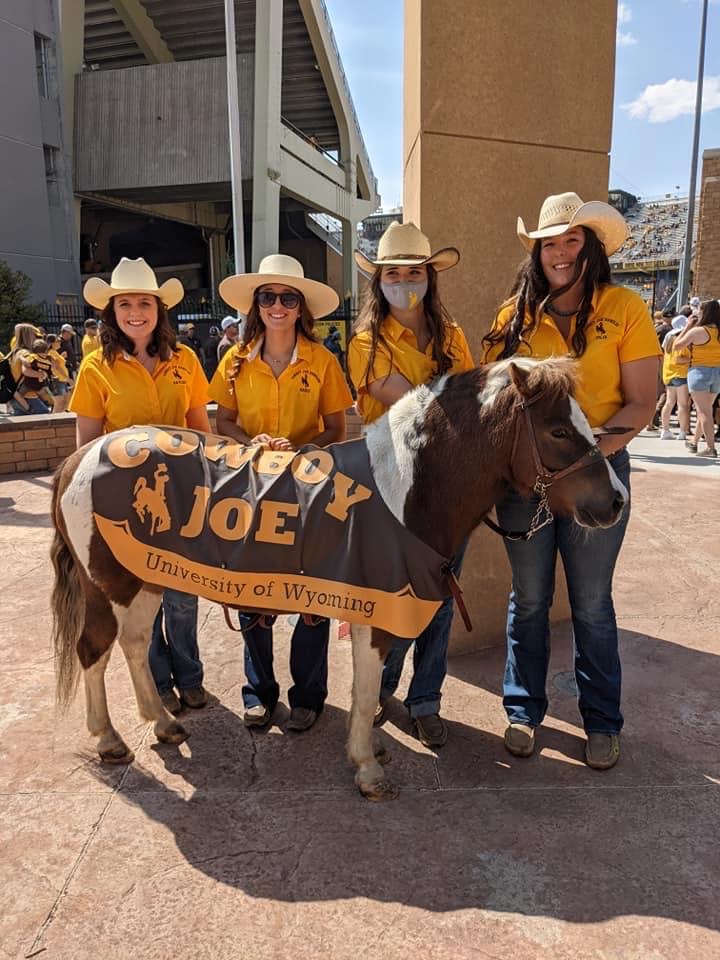 Cowboy Joe standing with his four handlers in the fall of 2021
