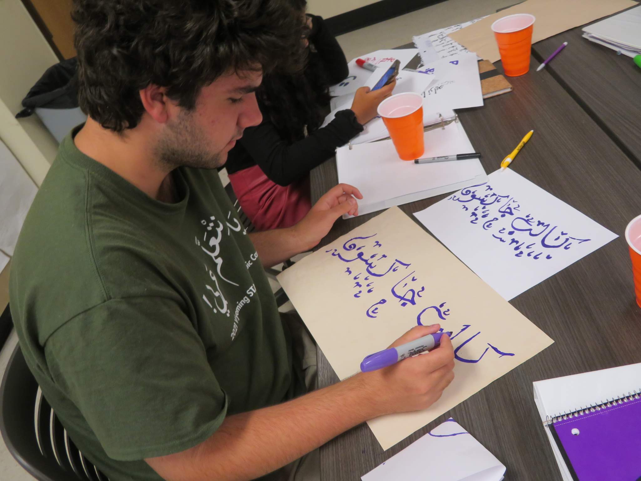 student practicing arabic calligraphy
