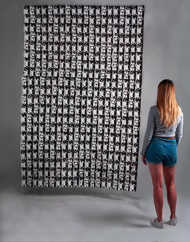 Woman standing in front a quilted prints
