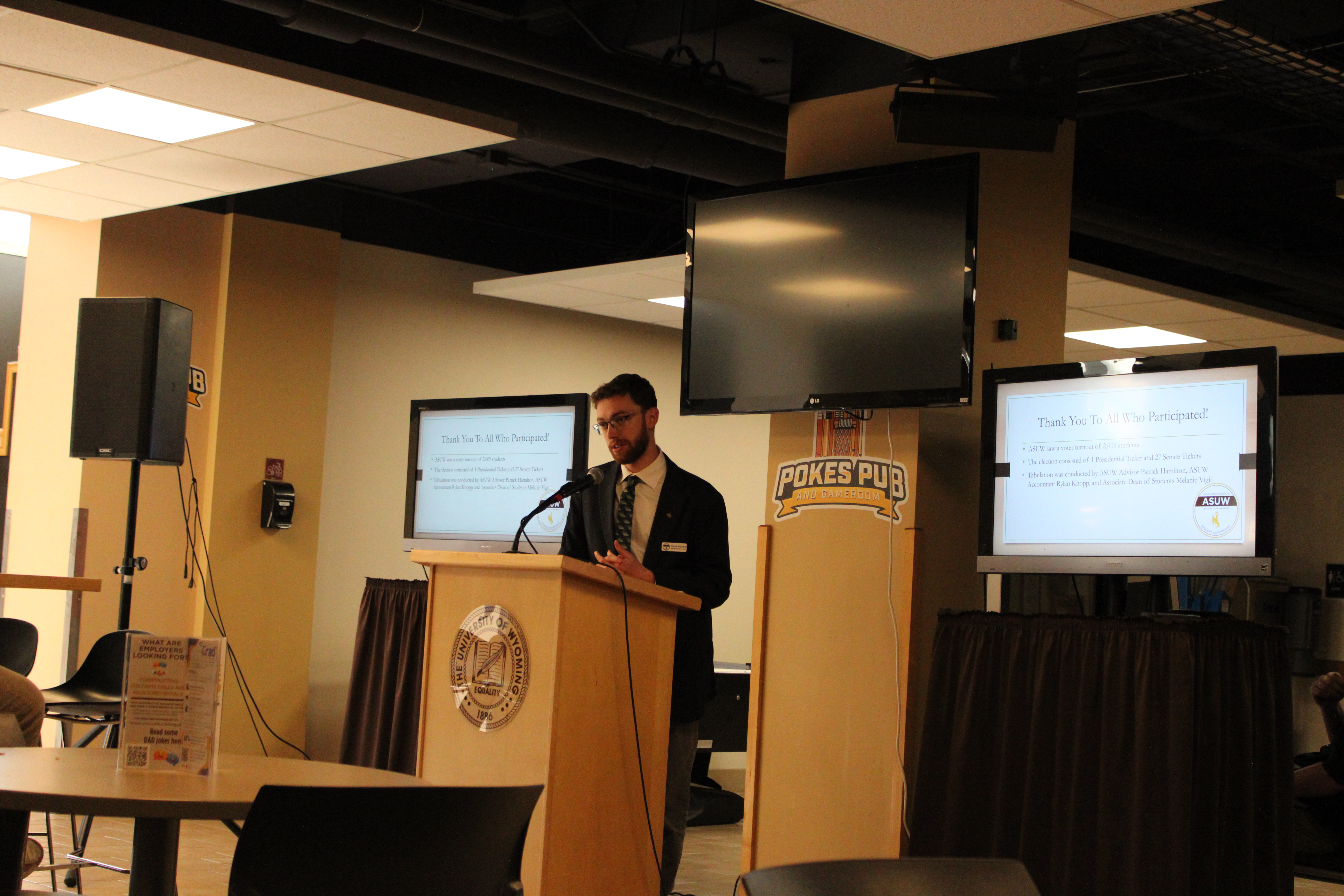A presenter presents using a podium in pokes pub