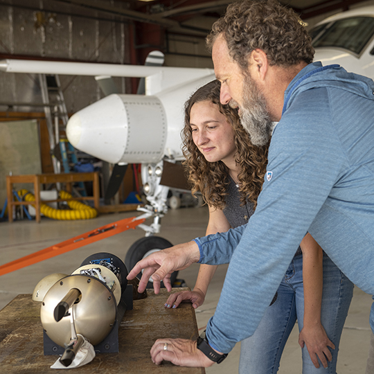 atmospheric science student with instructor in flight hangar