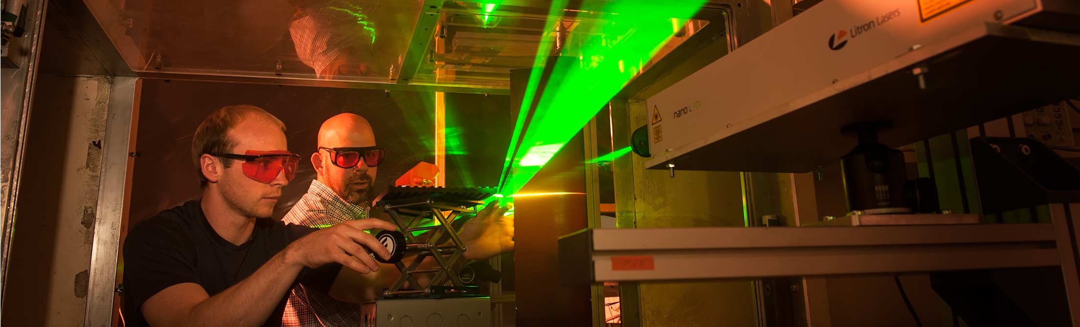 Men adjust laser in wind tunnel