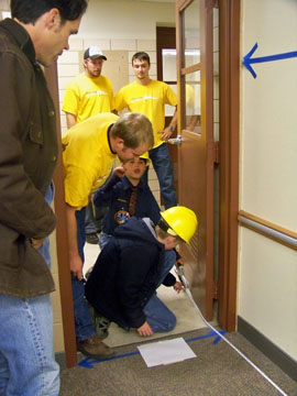 students working in doorway, measuring