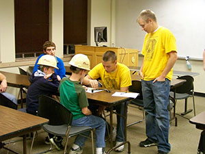 students brainstorming with hard hats on