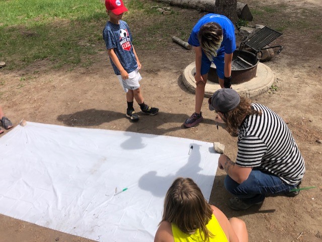 Campers work with a geographist to learn about latitude and longitude.