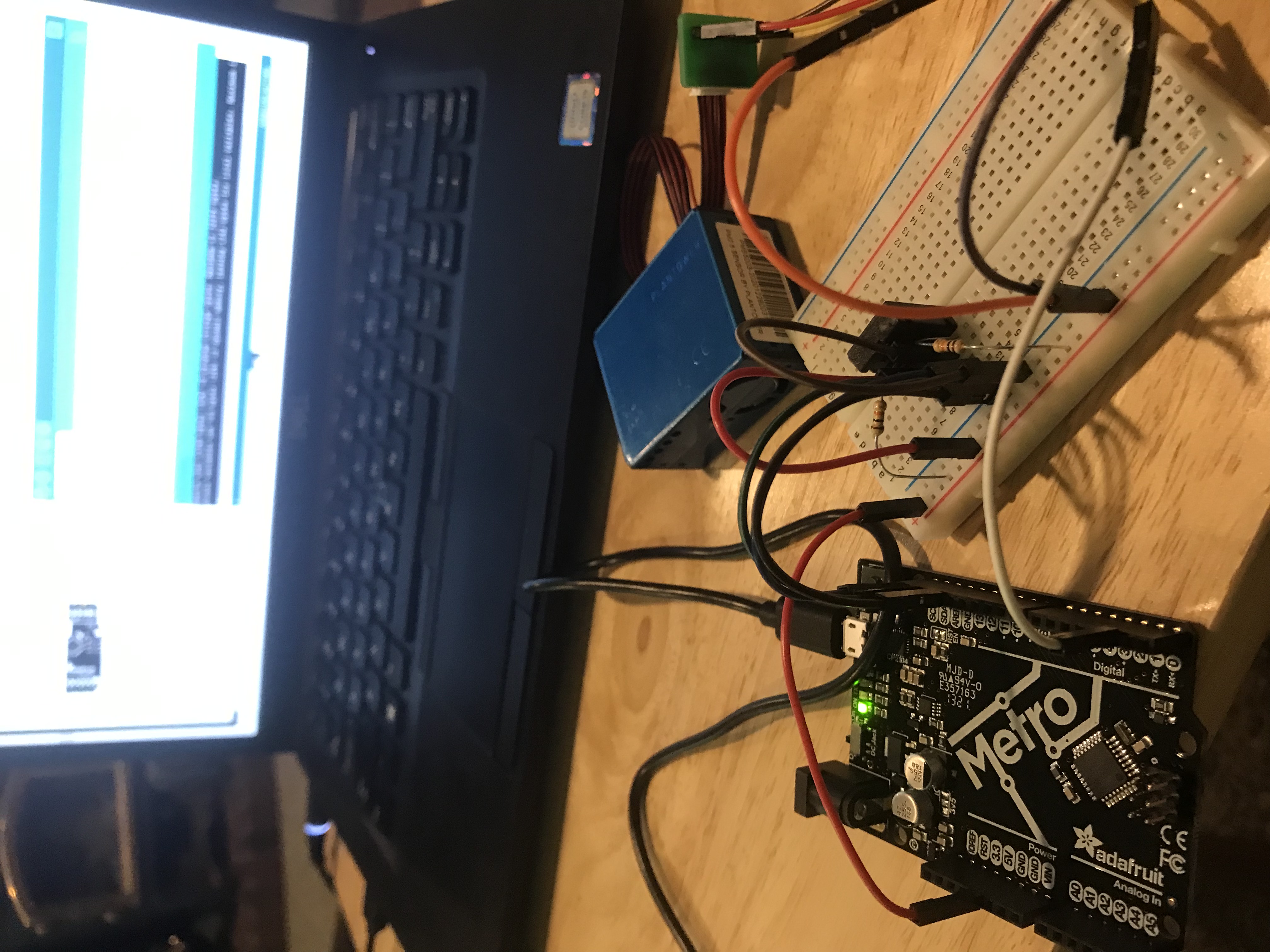 a breadboard with wires and a computer screen