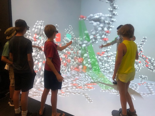 Students reaching out for molecules in the 3D Cave
