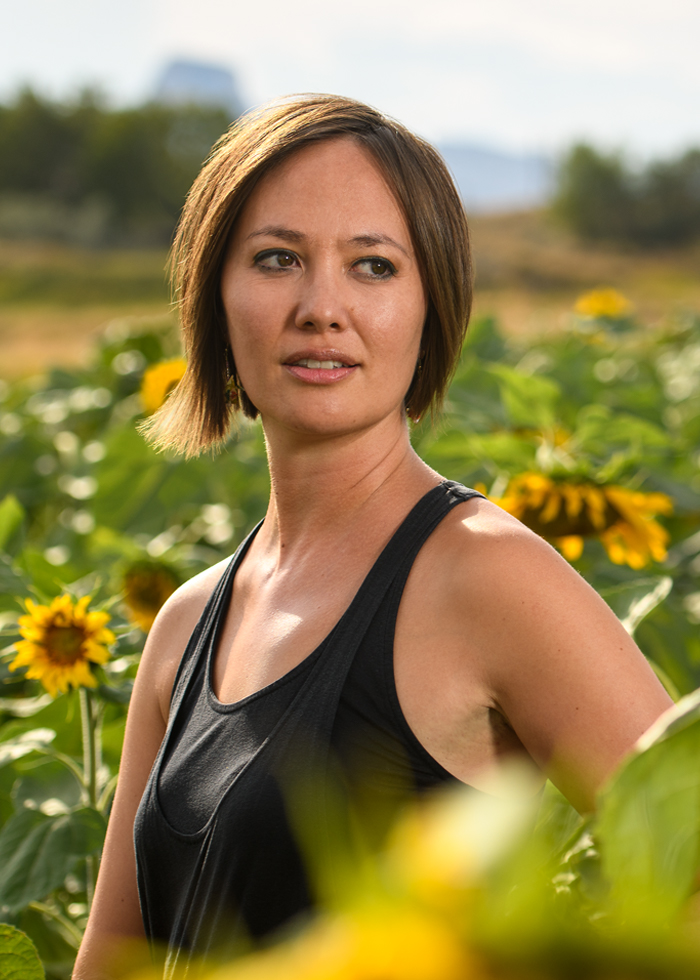 Image of Alumna Aura Newlin in a sunflower field