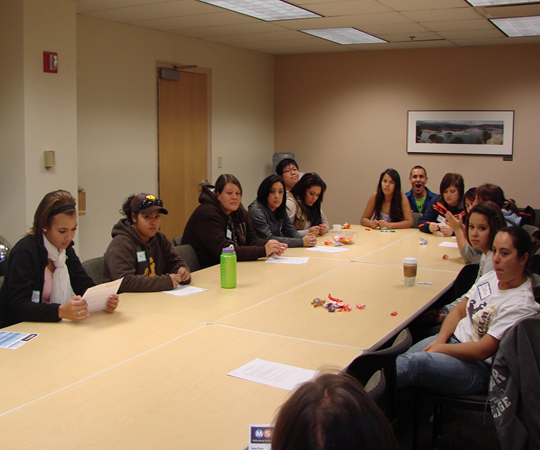 Students site together at a large conference table.