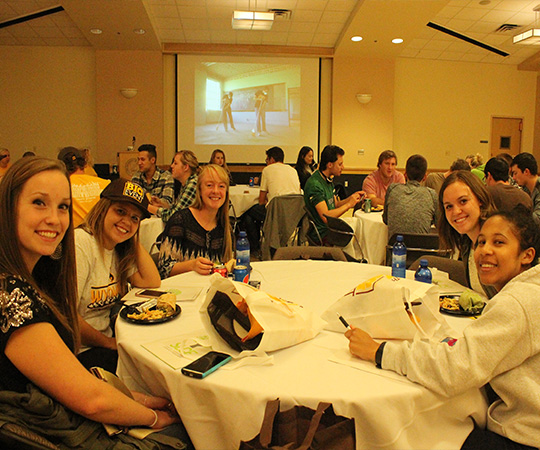 Students sit together at a banquet table.