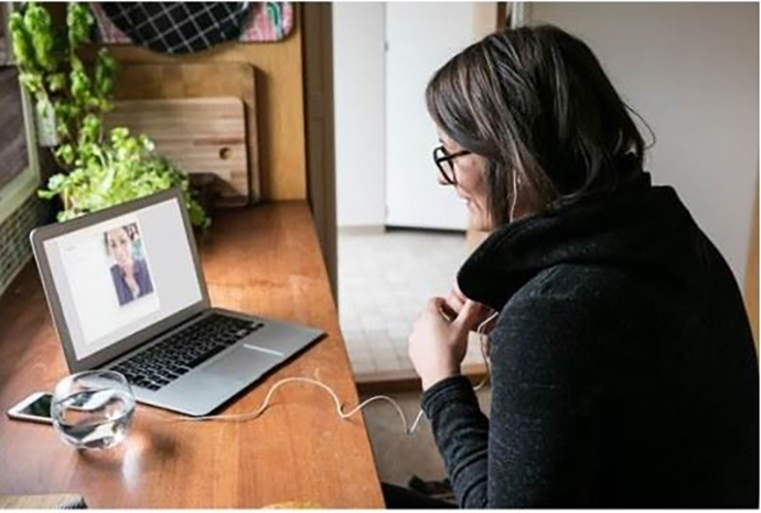 A woman prepares to meet with a therapy client via video chat.