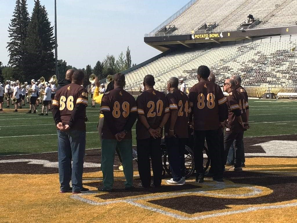 Members of the Black 14 watching the Wyoming Football Team warm up prior to the football game. 