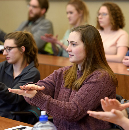 Student Alex Jacobson practices hand movements in a sign language class.