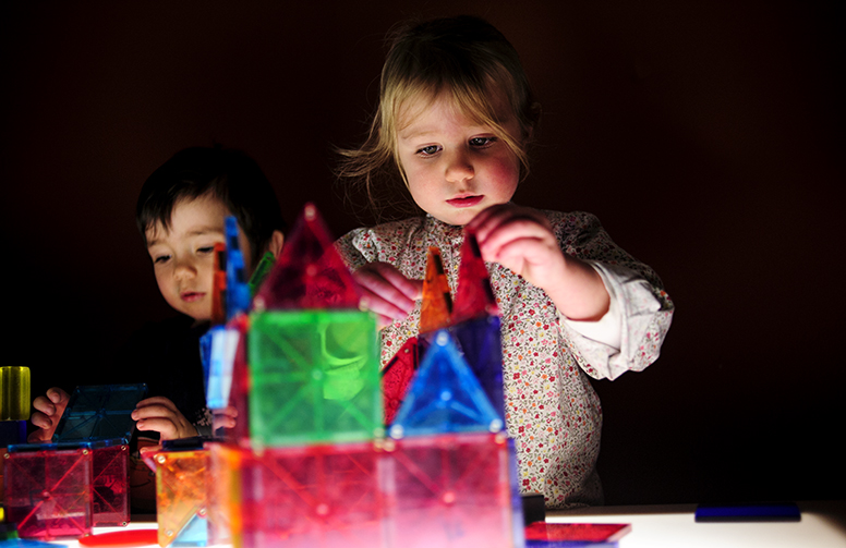 a child playing with lighted blocks