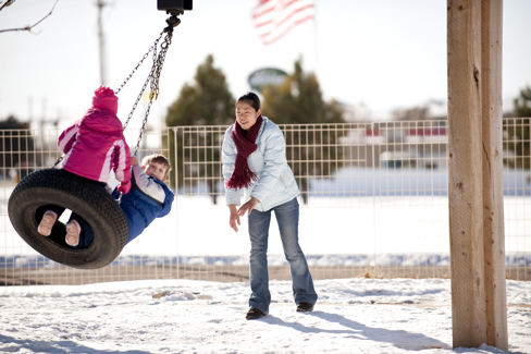 Student Pushing Children on Tire Swing