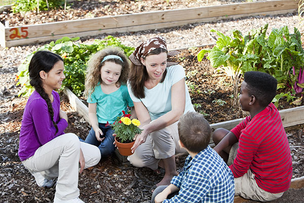 Student working with youth in a garden