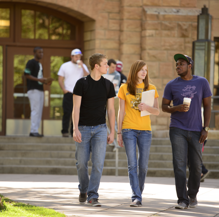 three students walking outside on campus