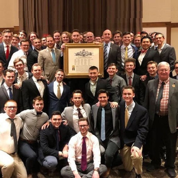 Group of college and alumni members of Kappa Sigma with their framed names of the new founders of the fraternity