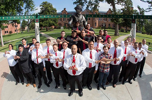 Phi Sigma Nu's Chief Convention, all men are in white shirts with a red tie showing their fraternity hand sign