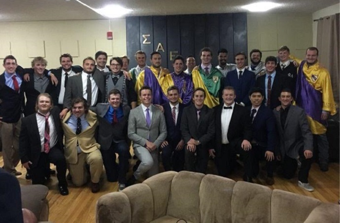 Members in robes and suits after being initiated inside the SAE house.