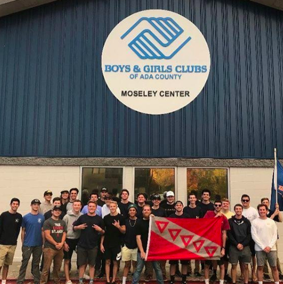 Members of the Fraternity outside of the Boys and Girls Club holding the TKE Flag